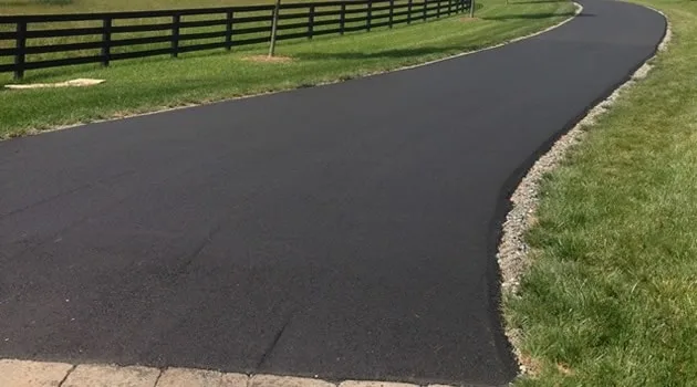Fresh asphalt paving along a property edge with clean transitions