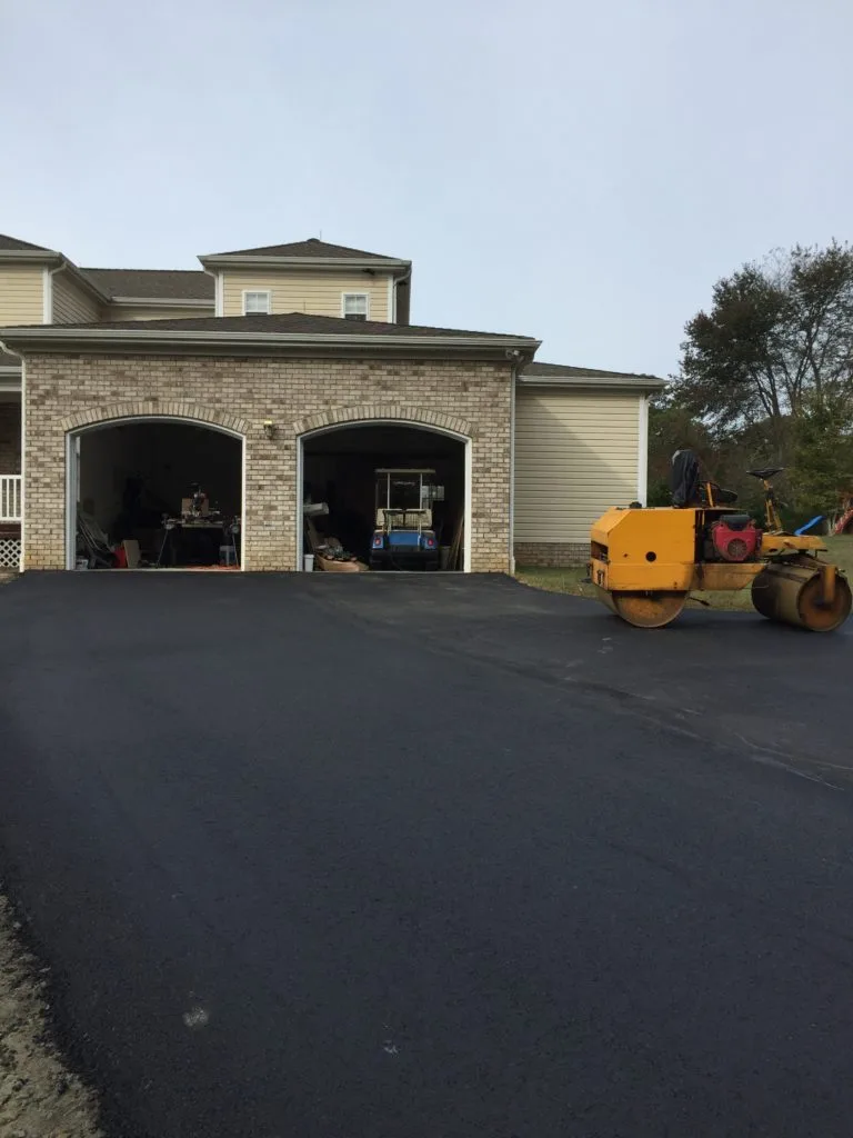 Asphalt paver laying a fresh mat of hot asphalt on a job site
