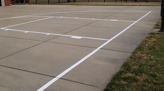 Freshly painted free-throw lane and boundary lines on an asphalt court