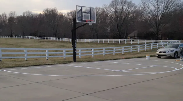 Fenced asphalt basketball court with crisp regulation striping