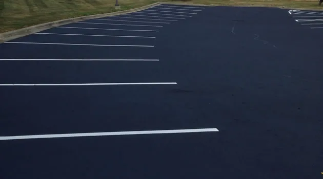 Freshly repaired parking lot with a bright white STOP marking