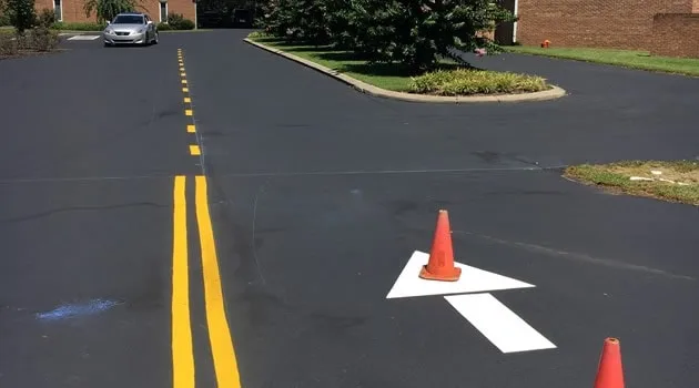 Fresh yellow directional arrow on a restored parking surface