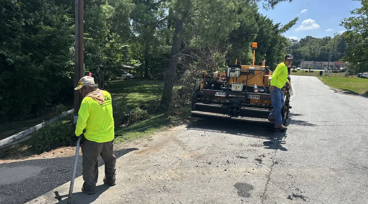 Asphalt paver and crew staging at the job site