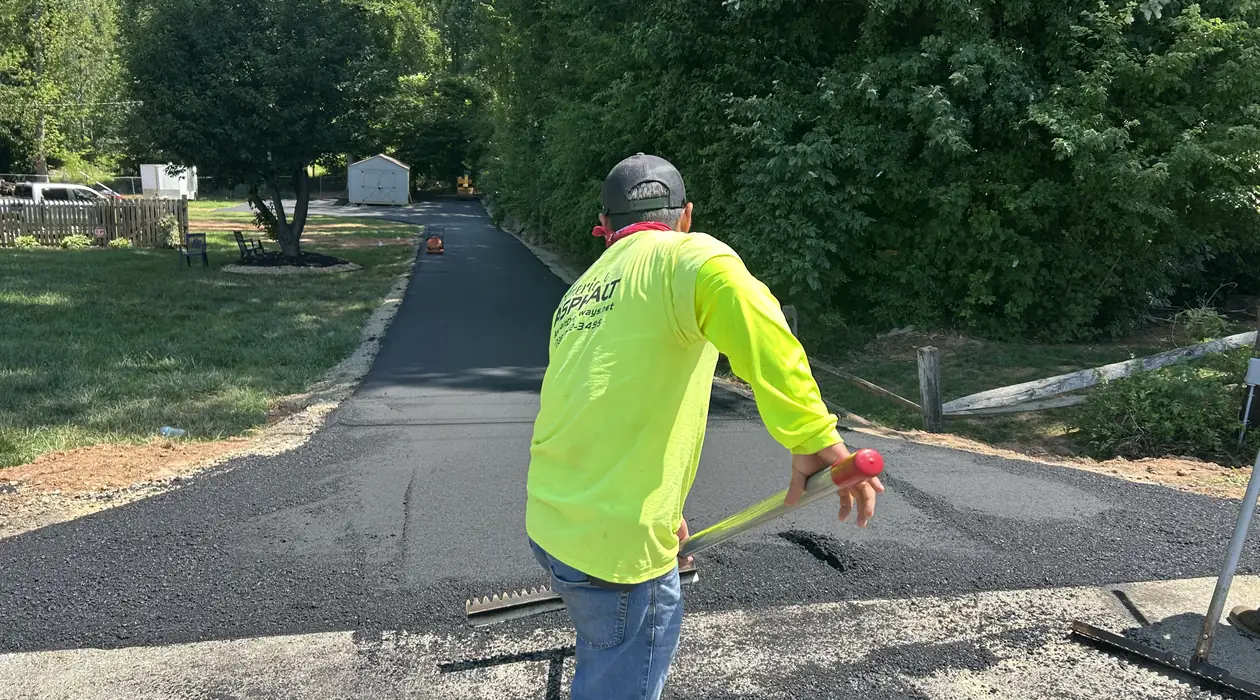 Crew screeding the fresh asphalt mat up the driveway