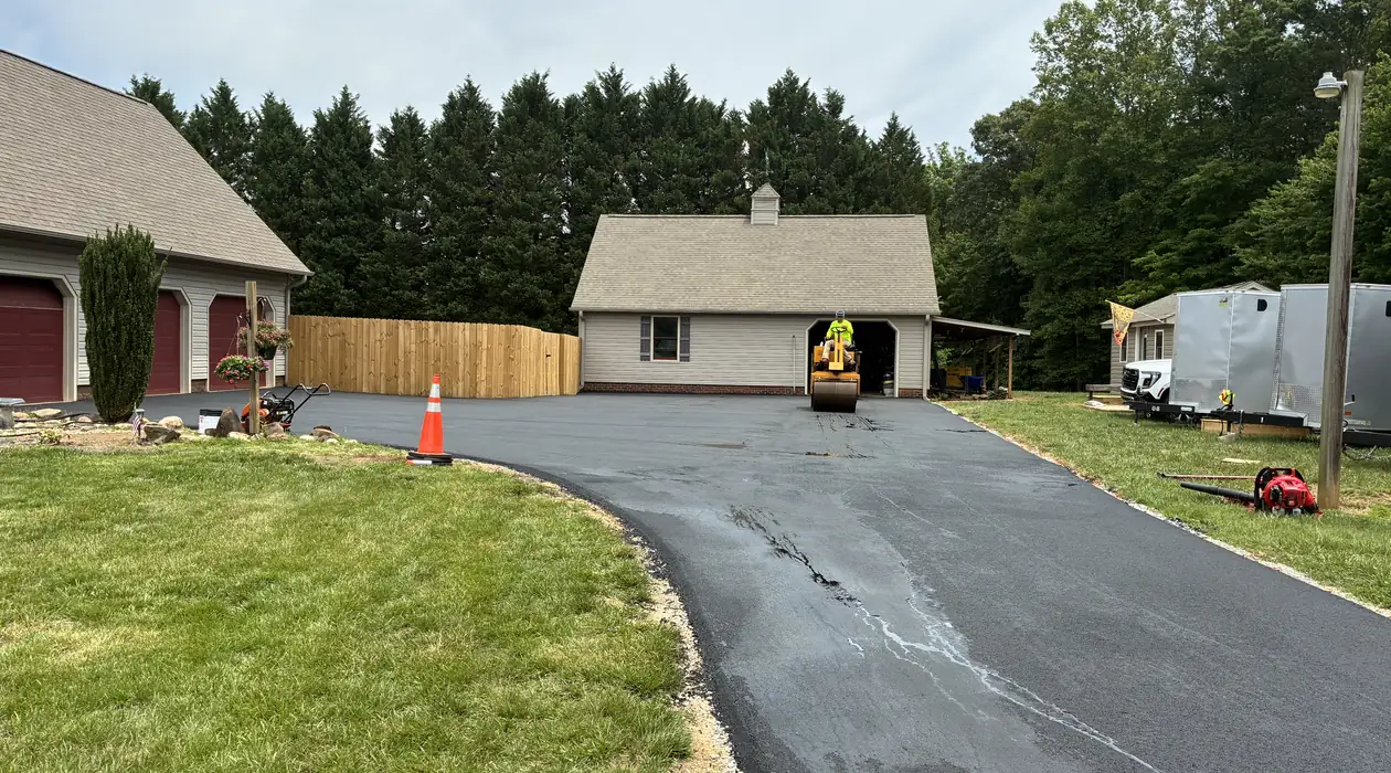 New asphalt driveway rolled smooth up to the garage doors