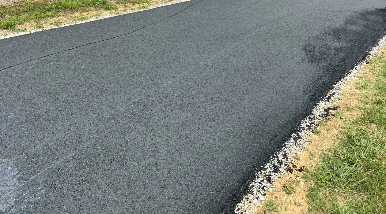 Crisp finished edge where new asphalt meets the stone shoulder