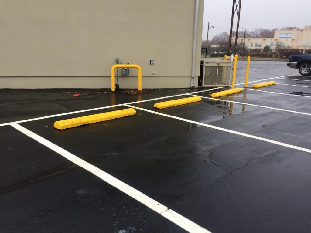 Sealed parking lot with fresh yellow stall lines and curb markings