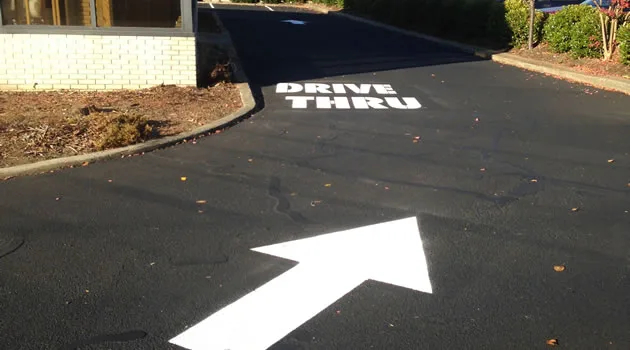 Deep-black freshly sealcoated commercial parking lot