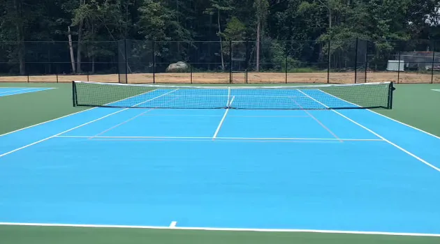 Finished blue tennis courts with new nets and regulation lines