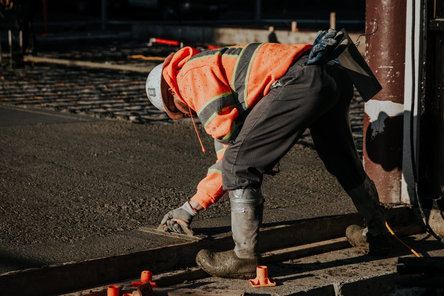 A construction worker paves asphalt on a new road.